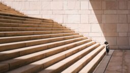 A kid looking up a flight of stairs showing the desire to go up, albeit baby steps. Just like the determination you need to accomplish your goals using micro goals. Success Through Failure episode 294: A Surprisingly Simple Trick To Staying On Track With Your Goals: A Power Tactic To Use Every Month