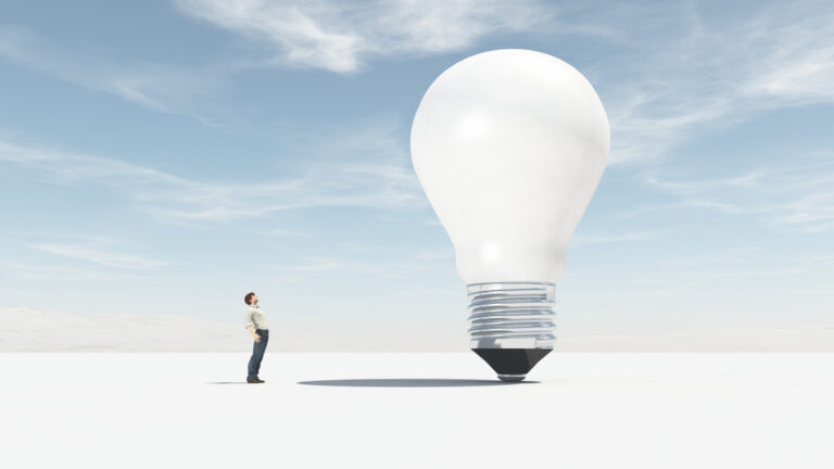 A man facing a giant lightbulb: Think big for Success Through Failure episode 296 Think Like Elon: Provocative Questions and Tactics for Unleashing Your Inner Greatness