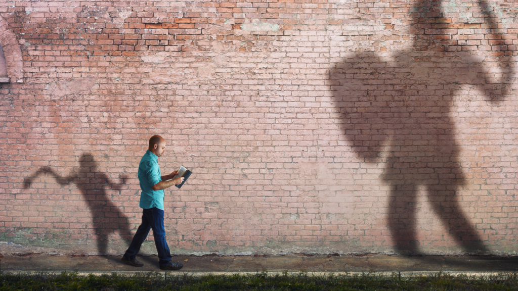 A David and Goliath-like image: The small man ready to take on the big challenges in his life (Success Through Failure episode 302: Overcoming Your Fear of Setting Scary BIG Goals: How to Set Your BHAG)