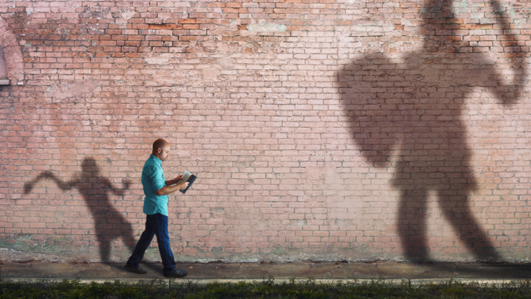 A David and Goliath-like image: The small man ready to take on the big challenges in his life (Success Through Failure episode 302: Overcoming Your Fear of Setting Scary BIG Goals: How to Set Your BHAG)