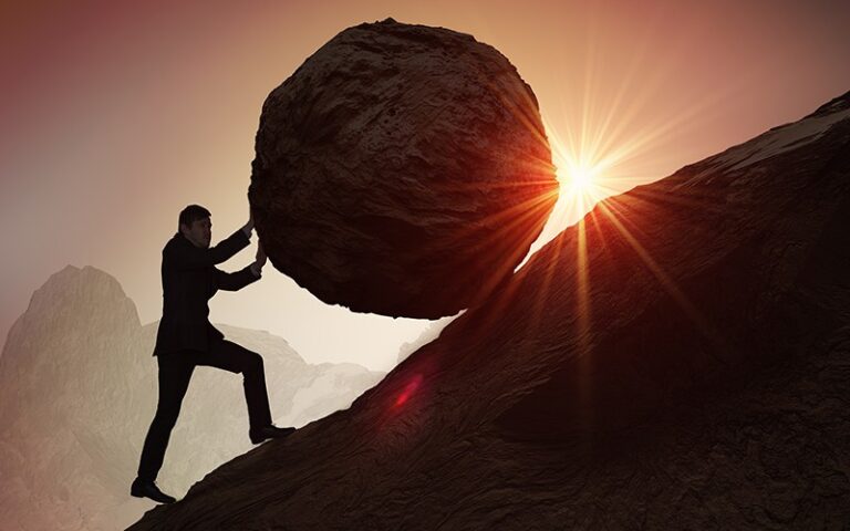 A man pushing a huge rock uphill (Success Through Failure episode 310: Should I Crush It Every Day? Or Get Off the War Path? How to Create Balanced Success)