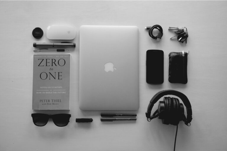 Gadgets like laptop, phone, headset, mouse, and a book (Success Through Failure episode 319: Jim's Favorite Books, Habits, and Gadgets For Consistency, Balance, and Success)
