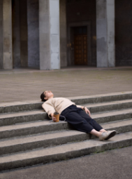 A lady lying on the stairs and holding a coffee (Success Through Failure episode 321: Get Unstuck: 5 Productive Pause  Questions That Will Instantly Amplify Your Results)